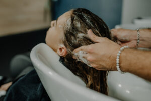 Cliente au bac en train de se faire, faire un shampoing pour cheveux gras au Salon Agutier à Pacé